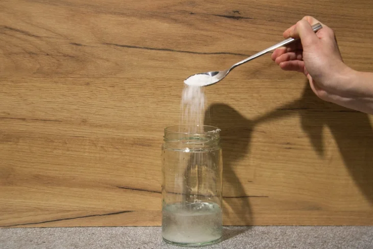 Sklenice, voda, lžíce Kyselina citronová na ručníky